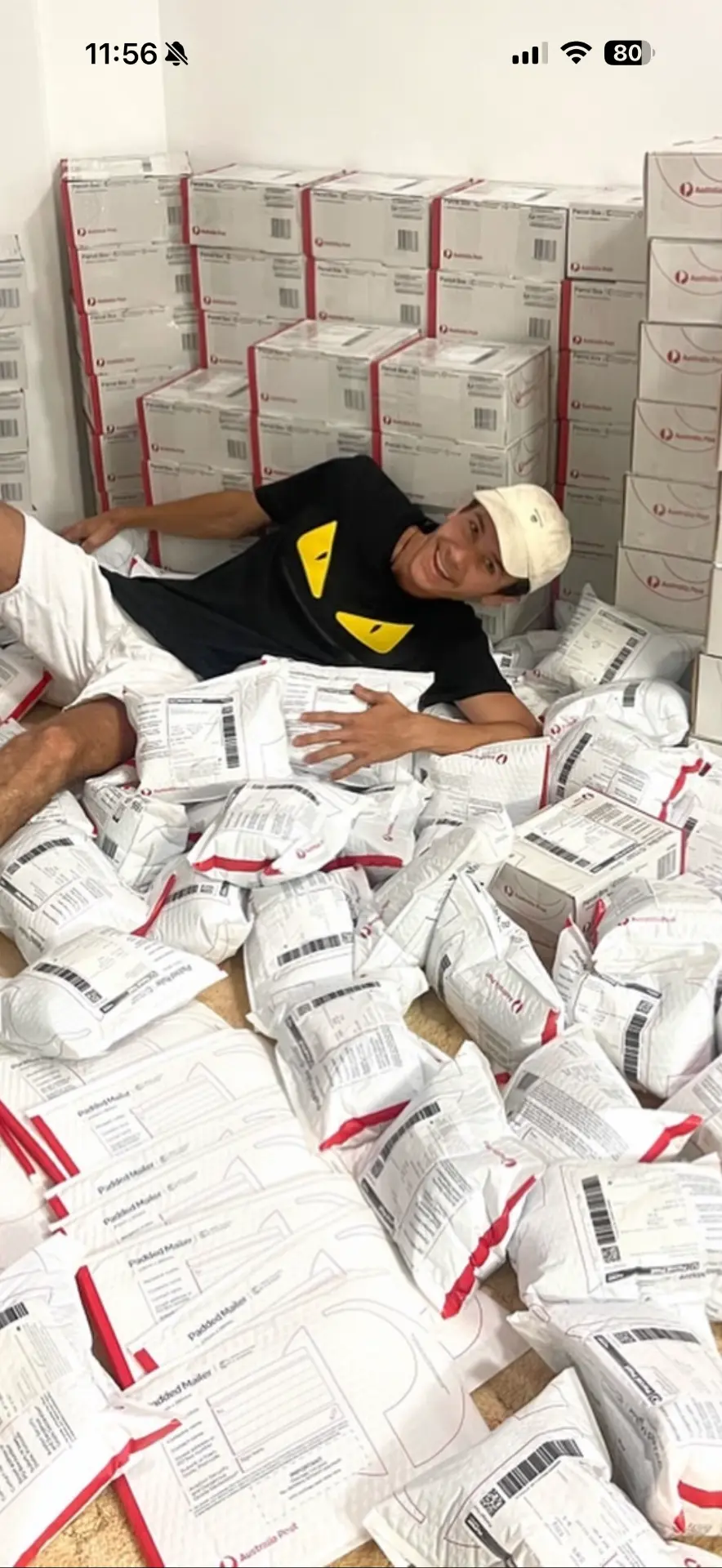 Tyler surrounded by hundreds of packed customer orders ready for shipping